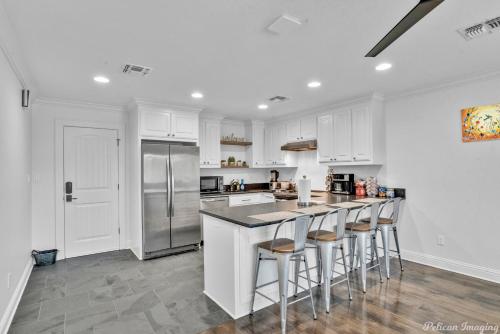 a kitchen with white cabinets and a island with bar stools at Lakefront Fully Loaded Apartment in Shreveport