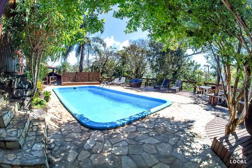 a swimming pool in the middle of a yard at Pousada Rosa in Praia do Rosa