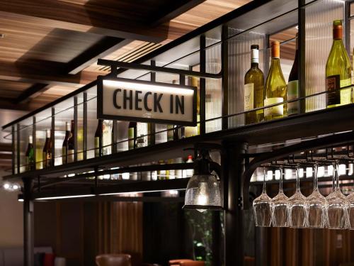 a shelf of wine bottles and glasses in a bar at Susukino Granbell Hotel in Sapporo
