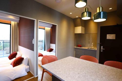 a kitchen with two beds and a table and chairs at the Moto Hotel Asakusa in Tokyo