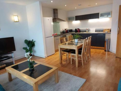 a living room with a table and a kitchen at Large 2 Bed, 2 Bath, Free Parking & WiFi in Sheffield