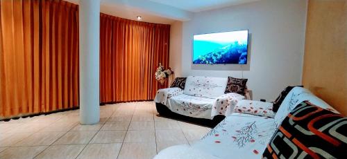 a living room with a couch and a tv at Apartamento en el corazón de Trujillo in Trujillo