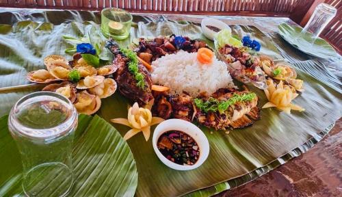 a plate of food on a banana leaf with rice at Maykenn Beach in Bantayan Island