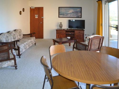 ein Wohnzimmer mit einem Tisch und einem Sofa in der Unterkunft Anchorage 10 in Tuncurry