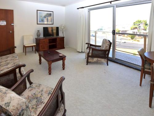 a living room with a couch and a tv at Anchorage 10 in Tuncurry