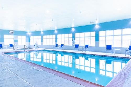 una grande piscina con sedie blu in un edificio di Holiday Inn Express Hereford, an IHG Hotel a Hereford