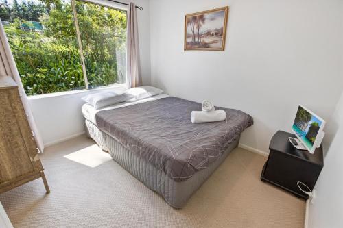 a small bedroom with a bed and a window at Lakes Edge in Lakes Entrance