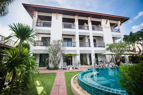 an exterior view of a hotel with a swimming pool at Phuket Monaburi Boutique Hotel in Rawai Beach