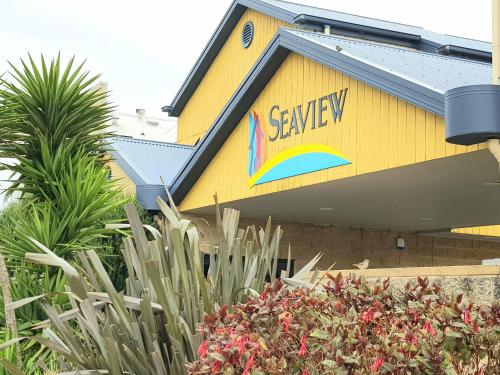 a yellow building with a savoy sign on it at Seaview Motel & Apartments in Apollo Bay