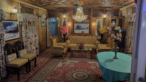 heritage geneva house boat في سريناغار: غرفة معيشة مع أريكة وكراسي وطاولة