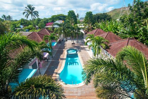 an aerial view of a resort pool with palm trees at Mad Monkey Kuta Lombok in Kuta Lombok