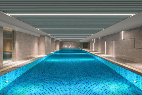 una piscina de agua azul en un edificio en Ascott Xiangjiang FFC Changsha, en Changsha