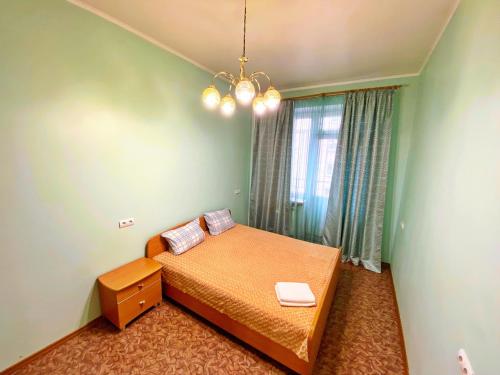 Habitación pequeña con cama y ventana en Baikal Apartment Vokzalnaya 14, en Krasnoyarsk