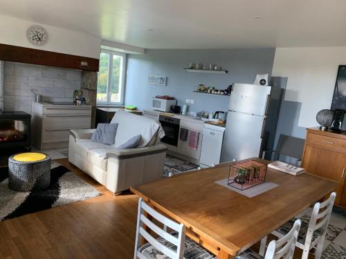 een keuken en een woonkamer met een tafel en een koelkast bij Fontanies en Aubrac in Laguiole
