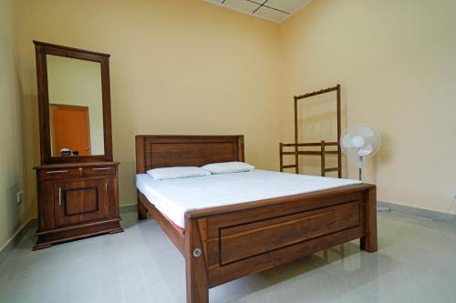 a bedroom with a bed and a dresser and a mirror at Green Haven Holiday Home in Anuradhapura