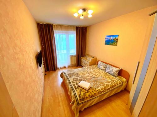 a small bedroom with a bed in a room at Baikal Apartments at Vzletka - Krasnoyarsk in Krasnoyarsk