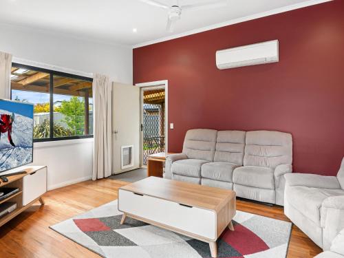 a living room with a couch and a table at Jillamatong 14 - 3BR House l Pet Friendly l Fenced Backyard l WiFi in Jindabyne