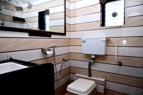 a bathroom with a toilet and a sink and a mirror at KK Tree Retreat Igatpuri in Igatpuri