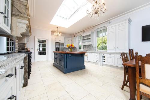 a large kitchen with a blue island in the middle at Swansea Valley Holiday Cottages in Cilybebyll