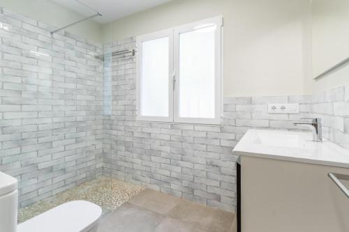 a white bathroom with a sink and a window at El Refugio - Quite and Spacious in Benissa