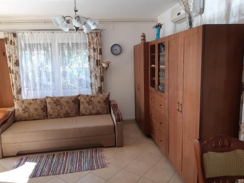 uma sala de estar com um sofá e uma janela em Ágnes Apartman em Igal