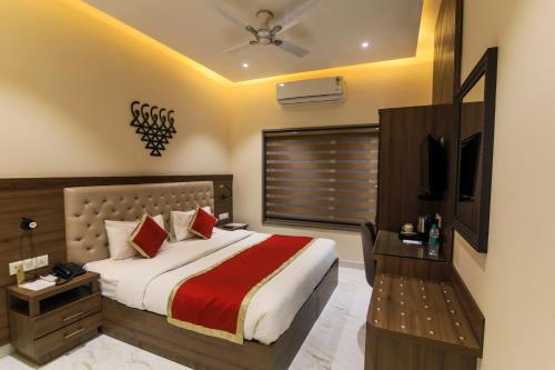 a bedroom with a large bed and a television at Vashishth Guest House in Rishīkesh