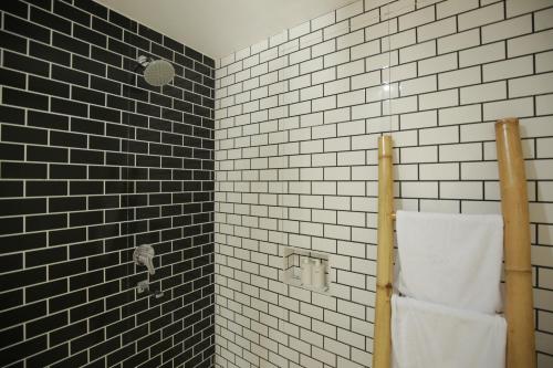 a bathroom with black and white tiles and a towel at The Sans Kuta Villas in Kuta Lombok