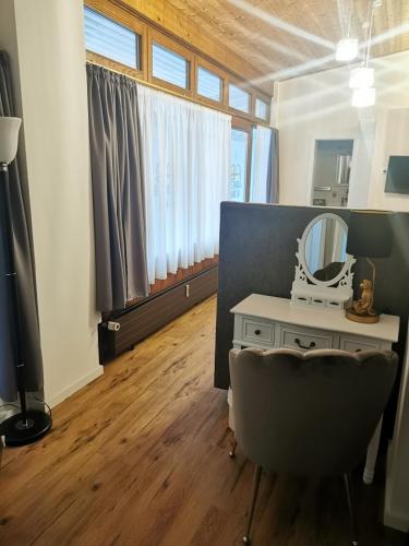a room with a vanity with a mirror and a chair at Altstadthotel Bachbräu in Weilheim in Oberbayern