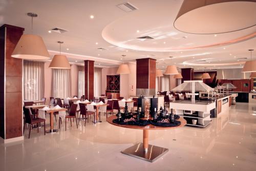 a restaurant with tables and chairs in a room at Vila Gale Marina in Vilamoura