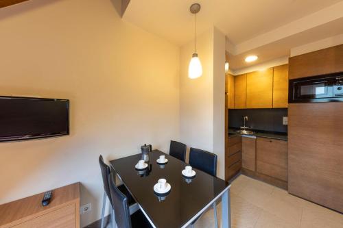 a kitchen and dining room with a table and chairs at Aparthotel Trainera in Esterri d'Àneu