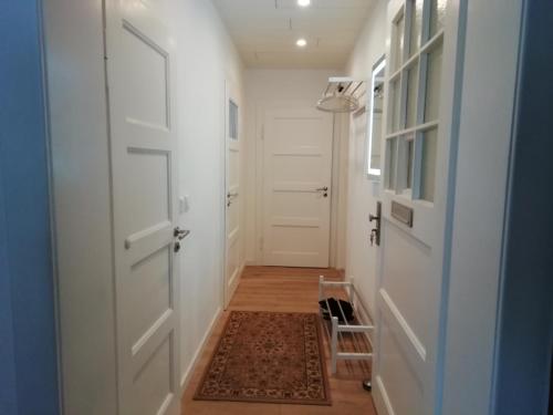 a hallway with two white doors and a rug at Ferienwohnung Ahrens in Hoyerswerda