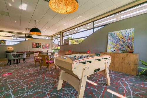 a game room with a foosball table in a restaurant at Kyriad Prestige Beaune le Panorama in Beaune