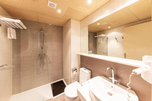 a bathroom with a toilet and a sink and a shower at Aparthotel Trainera in Esterri d'Àneu