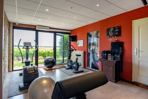 a gym with orange walls and a room with exercise equipment at Kyriad Prestige Beaune le Panorama in Beaune