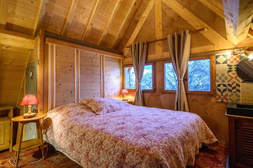 - une chambre avec un lit dans une pièce dotée de plafonds en bois dans l'établissement Petit Rochebrune, à Orcières