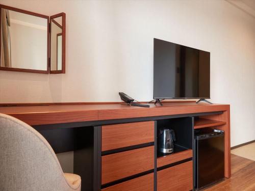 a room with a desk with a tv and a mirror at THE GRAND HOTEL GINOWAN in Ginowan