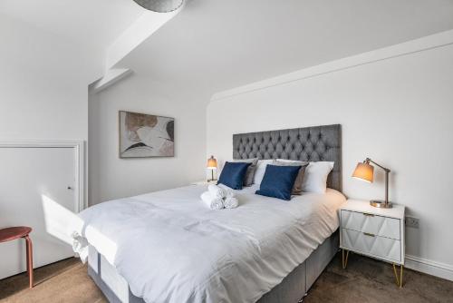 a bedroom with a large white bed with blue pillows at NEW Stunning & Stylish 2BD Flat Paignton Devon in Paignton