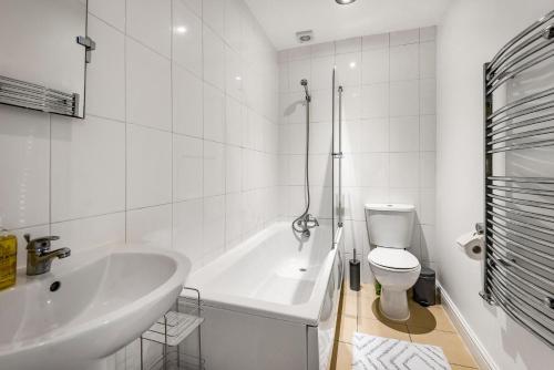 a bathroom with a tub and a toilet and a sink at NEW Stunning & Stylish 2BD Flat Paignton Devon in Paignton