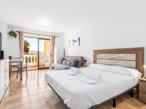 a bedroom with a bed and a living room at 651 Bright establishment, heated pool and Wi Fi in Los Cristianos