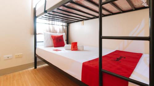 um quarto com 2 beliches e almofadas vermelhas em RedDoorz Plus Billy's Resort Oslob em Oslob