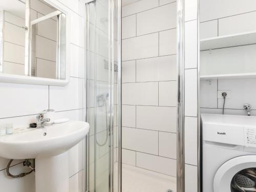 a white bathroom with a sink and a washing machine at 651 Bright establishment, heated pool and Wi Fi in Los Cristianos