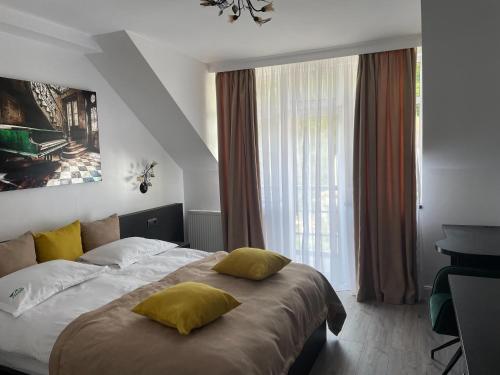 sypialnia z łóżkiem z żółtymi poduszkami w obiekcie 7Soapte w Braszowie