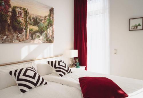 a white bed with black and white pillows on it at Pension Engel in Grifte