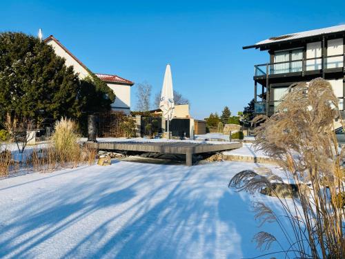 a snow covered street with a building and a fountain at Hotel My Schildow in Schildow