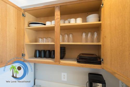 a kitchen cupboard with plates and dishes in it at Windy Hill Villa 2 - Beach Retreat in Myrtle Beach