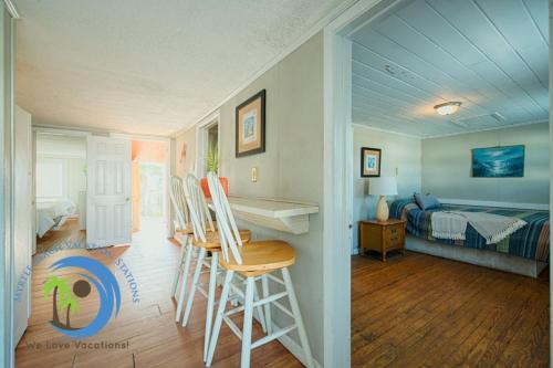 a room with a bed and a desk and chairs at Oceanfront Ocean Drive Cottage in Myrtle Beach