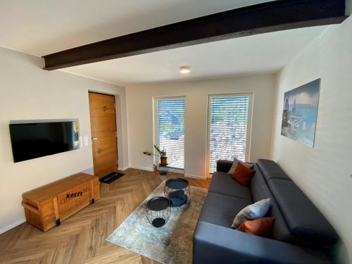 a living room with a couch and a flat screen tv at Mosel-FeWo-JuLe in Enkirch