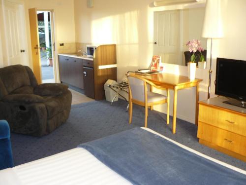 a hotel room with a desk and a chair at Australia Park Motel in Albury