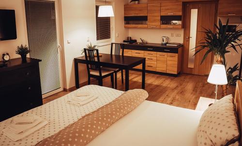1 dormitorio con cama, mesa y cocina en Apartmán Wellness Sedmihorky, en Turnov