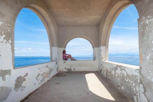 a woman sitting in a window looking out at the ocean at Studio 4827-3 for 4 Pers in Nerezine in Nerezine